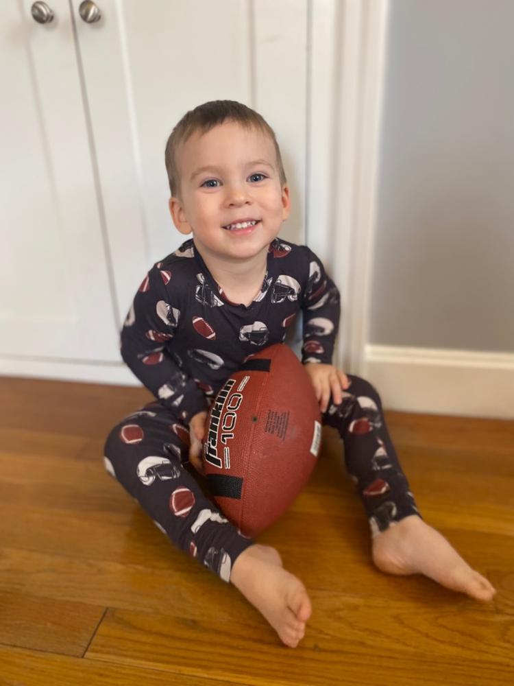 Customer photo: boy with a football in navy pajamas